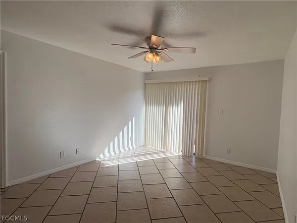 en empty room with windows and ceiling fan