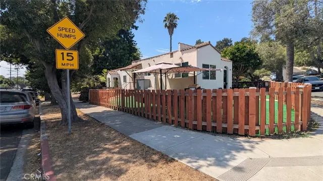 a view of a small house with wooden fence