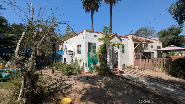 a front view of a house with a yard and potted plants