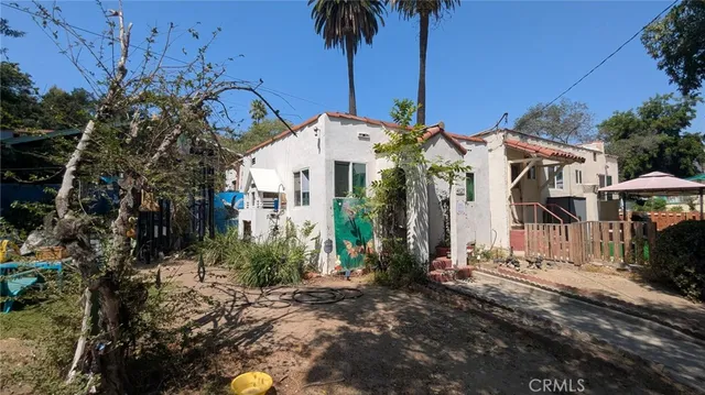 a front view of a house with a yard and potted plants
