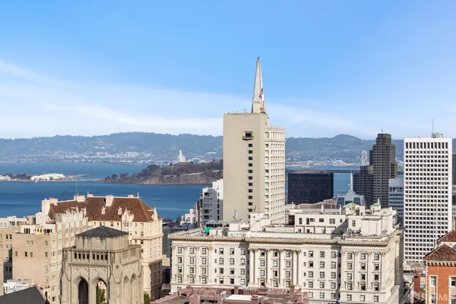 a view of a brick house with a clock and a large tree