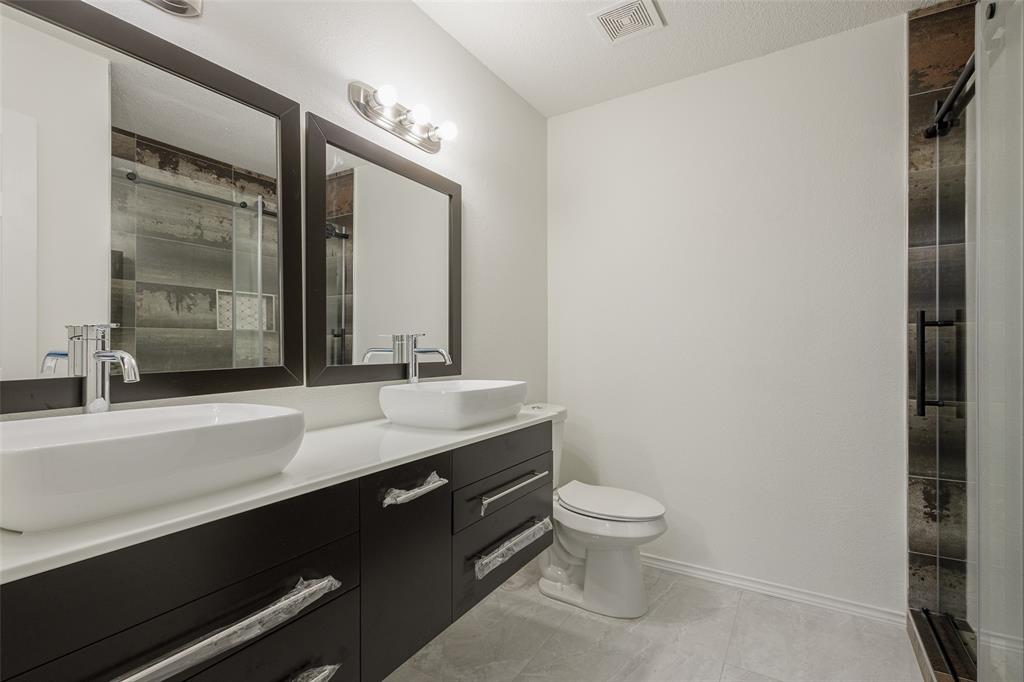 3901 Kathryn Way McKinney, TX 75070 - Photo 18 of 26 a bathroom with a granite countertop sink a toilet and a mirror