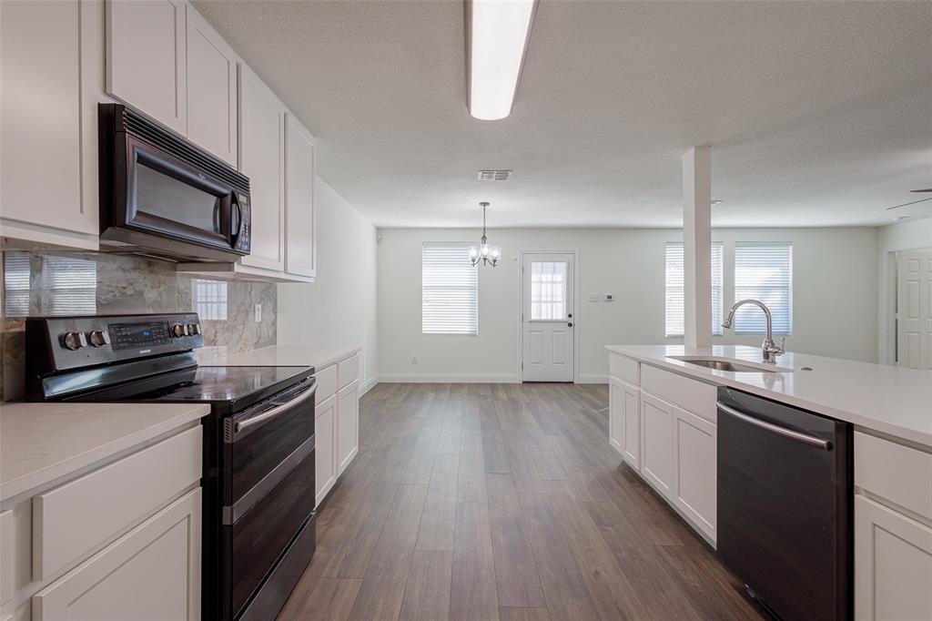 3901 Kathryn Way McKinney, TX 75070 - Photo 3 of 26 a kitchen with stainless steel appliances granite countertop a stove a sink and a microwave