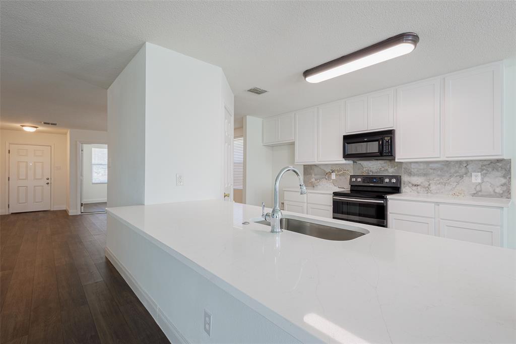 3901 Kathryn Way McKinney, TX 75070 - Photo 5 of 26 a kitchen with sink a microwave and cabinets