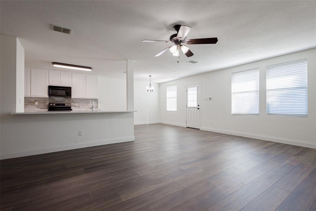 3901 Kathryn Way McKinney, TX 75070 - Photo 7 of 26 a view of an empty room with window and wooden floor