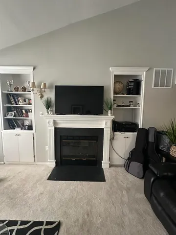 a living room with furniture a flat screen tv and a fireplace