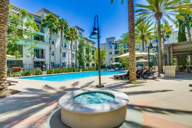 a view of a white building with palm trees and plants