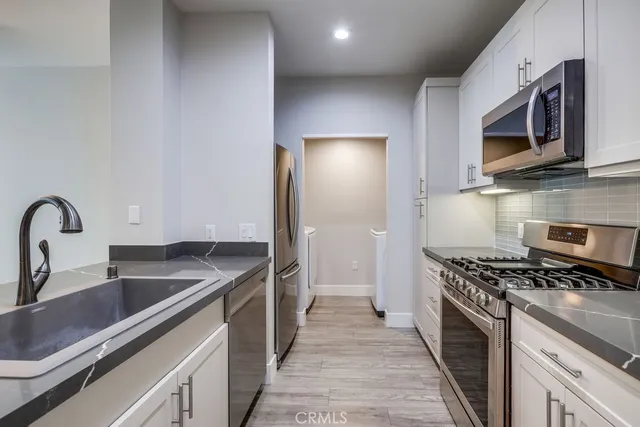 a kitchen with stainless steel appliances granite countertop a sink stove and microwave