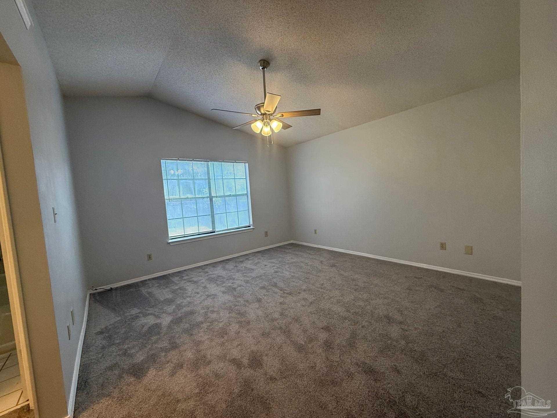 2715 Summertree Lane Gulf Breeze, FL 32563 - Photo 17 of 25 an empty room with windows and chandelier fan