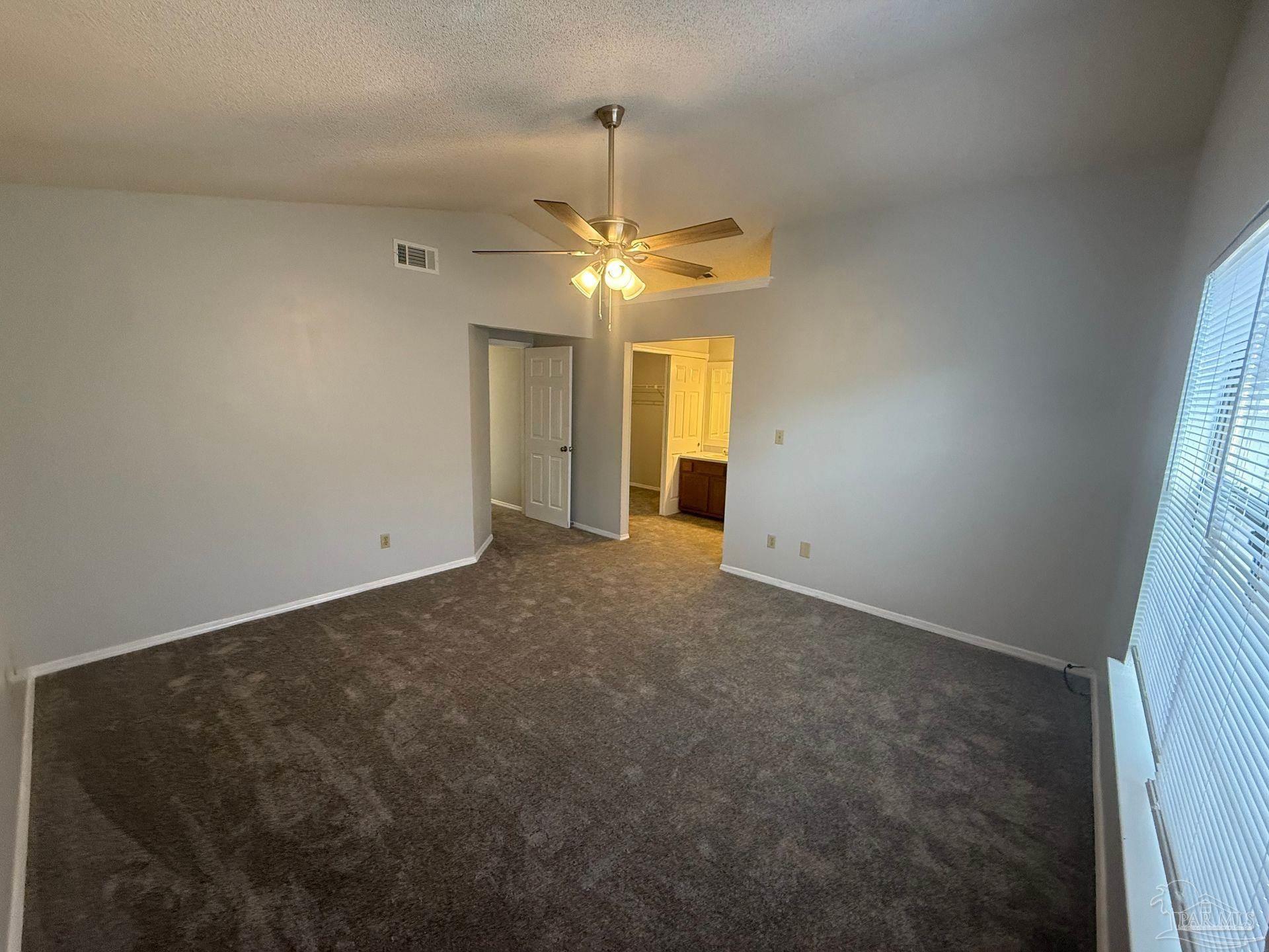 2715 Summertree Lane Gulf Breeze, FL 32563 - Photo 19 of 25 an empty room with a chandelier fan and windows