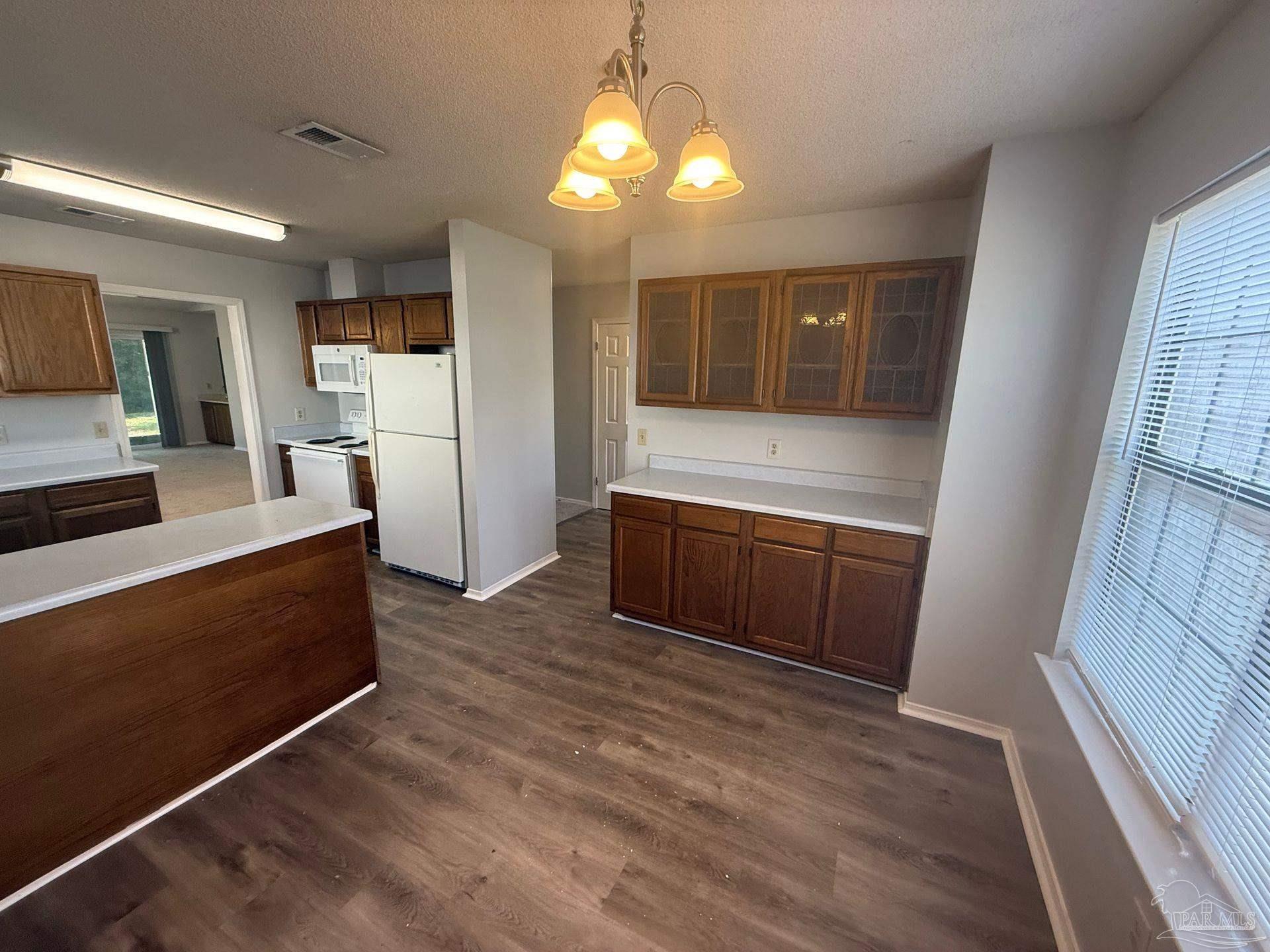 2715 Summertree Lane Gulf Breeze, FL 32563 - Photo 9 of 25 a kitchen with a refrigerator and a stove top oven