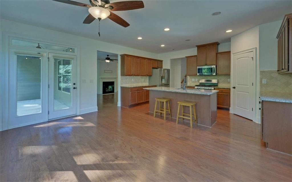255 Abbington Way Clarkesville, GA 30523 - Photo 13 of 49 a kitchen with stainless steel appliances kitchen island granite countertop a stove top oven a sink a dining table and chairs