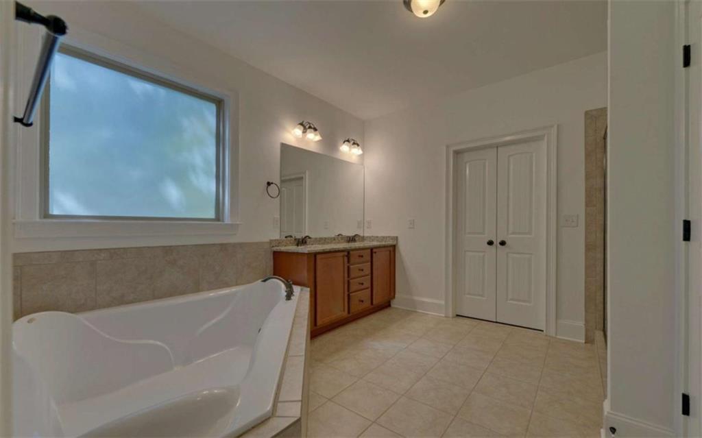 255 Abbington Way Clarkesville, GA 30523 - Photo 23 of 49 a bathroom with a tub a sink and wooden cabinets