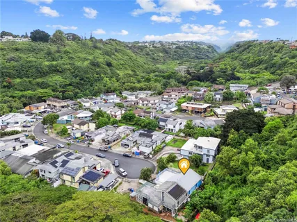 an aerial view of a city with lots of residential buildings and mountain view in back
