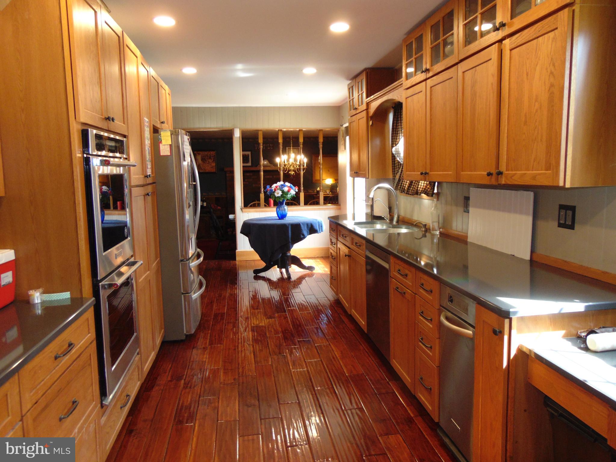 12 Mallard Drive Tabernacle, NJ 08088 - Photo 8 of 31 a open kitchen with stainless steel appliances granite countertop a refrigerator a sink dishwasher a stove and white countertops with wooden floor