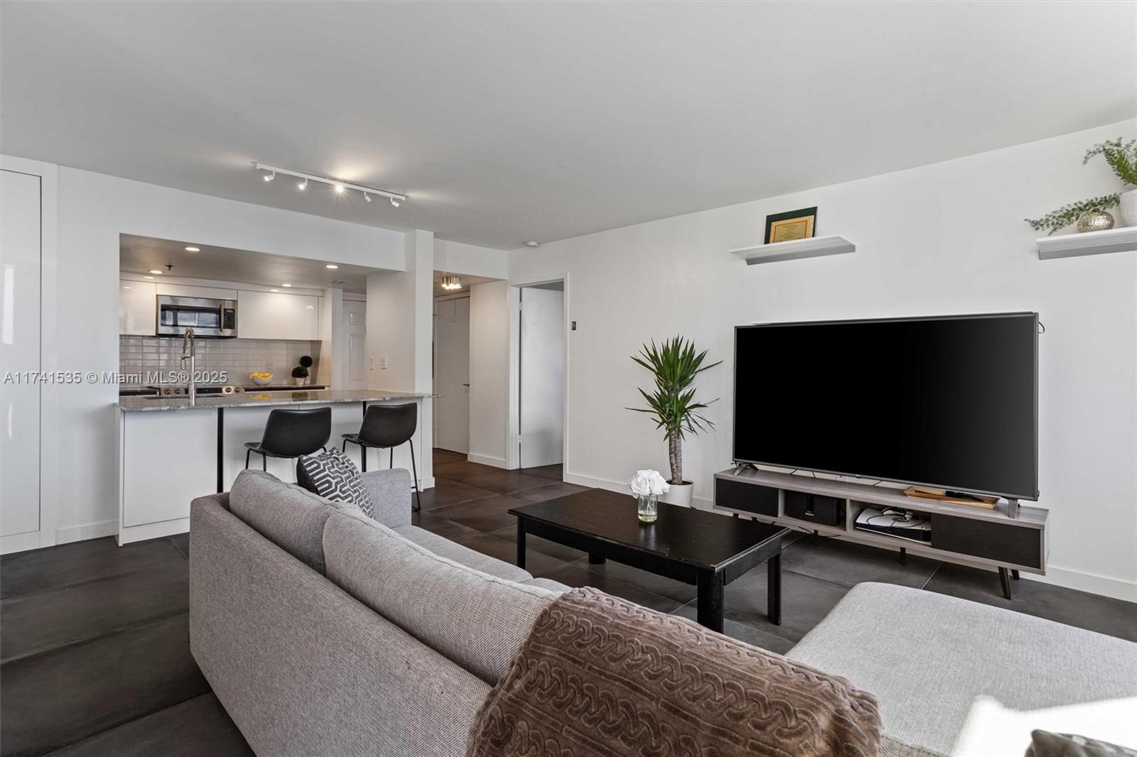 540 Brickell Key Drive, Unit 1519 Miami, FL 33131 - Photo 13 of 48 a living room with furniture and a flat screen tv