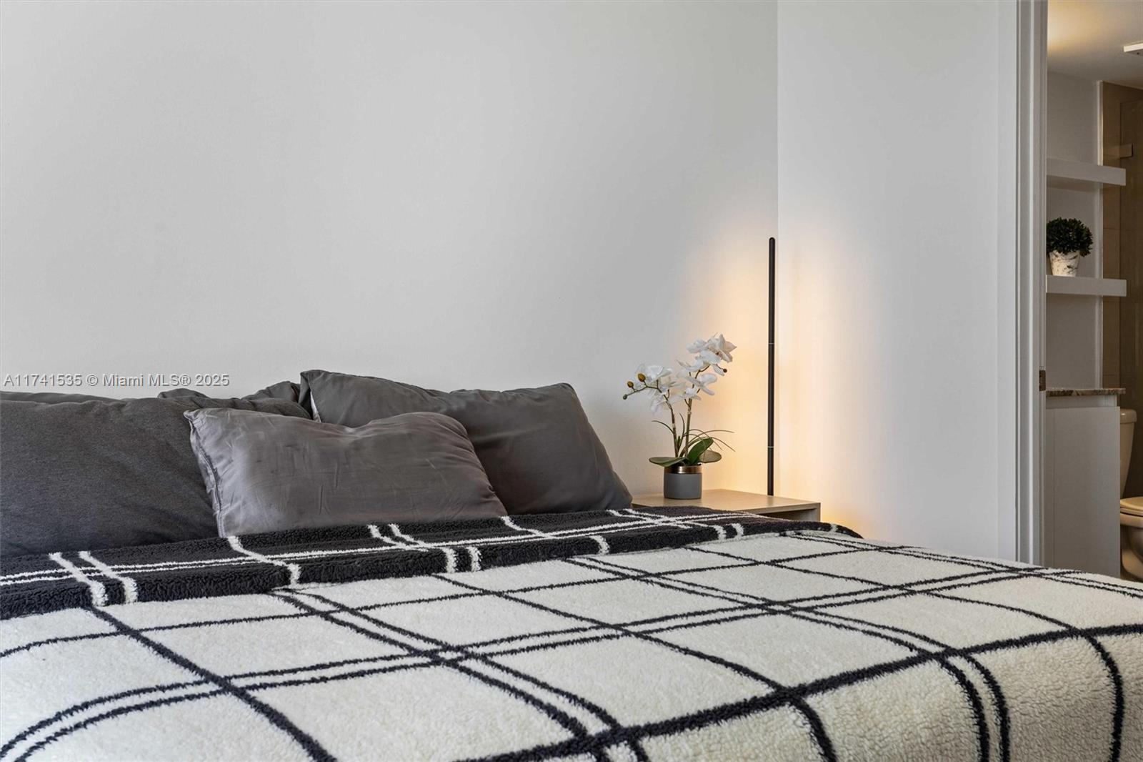 540 Brickell Key Drive, Unit 1519 Miami, FL 33131 - Photo 22 of 48 a bed sitting in a bedroom next to a window with potted plants