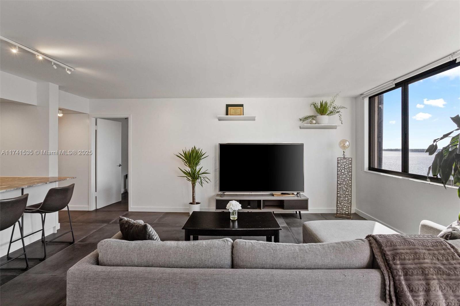 540 Brickell Key Drive, Unit 1519 Miami, FL 33131 - Photo 3 of 48 a living room with furniture and a flat screen tv