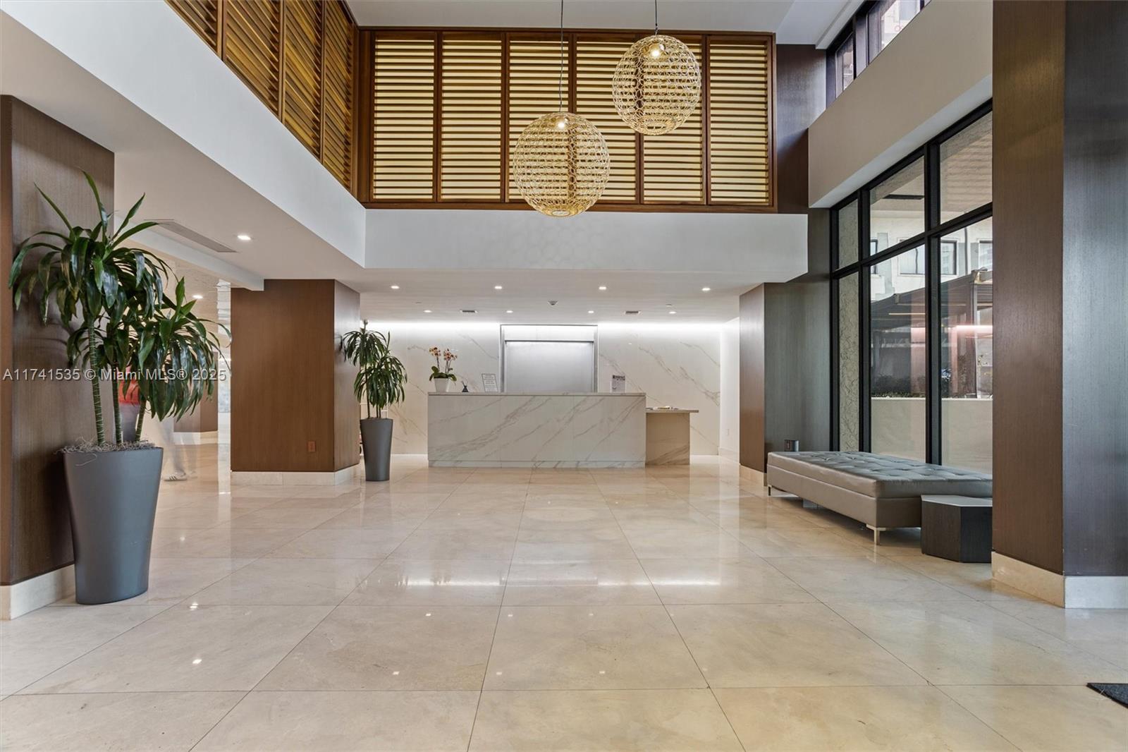 540 Brickell Key Drive, Unit 1519 Miami, FL 33131 - Photo 38 of 48 a view of a hallway with a glass door and furniture