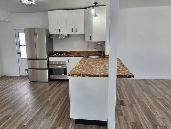 a kitchen with granite countertop stainless steel appliances and wooden floor