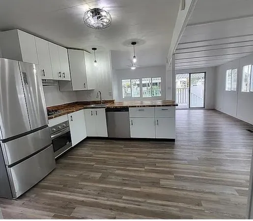 a kitchen with stainless steel appliances a refrigerator and wooden floor