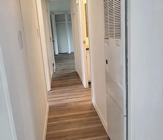 a view of a hallway with wooden floor and staircase