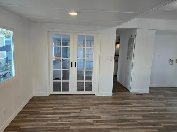 a view of a livingroom with wooden floor and windows