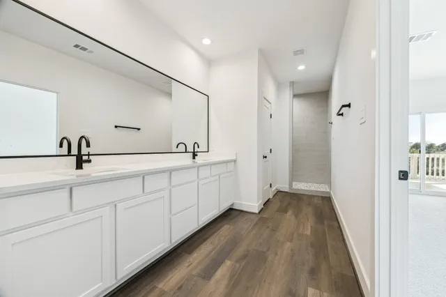a spacious bathroom with double vanity and mirrors