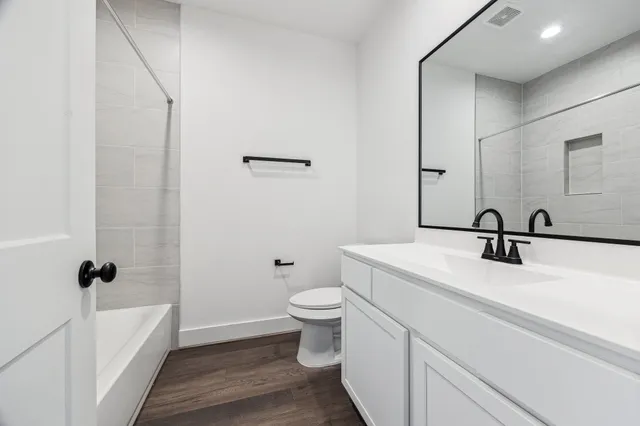 a bathroom with a sink a toilet and shower