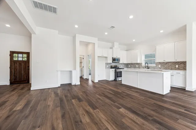 a view of kitchen with granite countertop cabinets and refrigerator