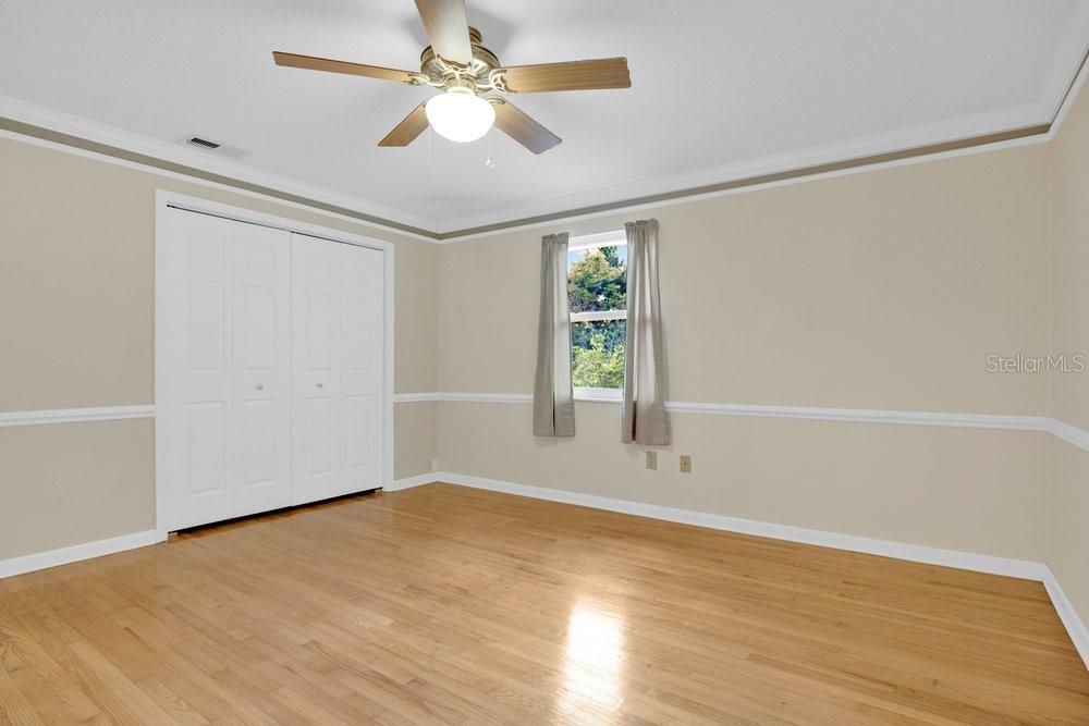 5137 Mt Plymouth Road Apopka, FL 32712 - Photo 19 of 58 an empty room with wooden floor chandelier fan and windows