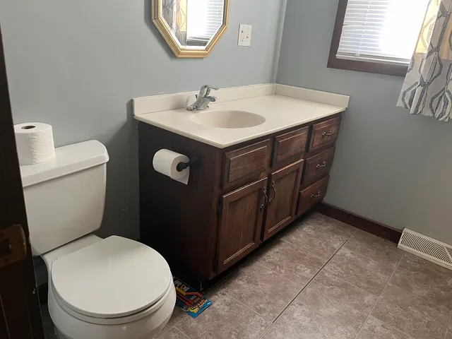 a bathroom with a toilet sink and mirror