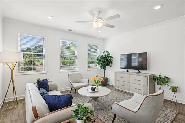 a living room with furniture a flat screen tv and a large window