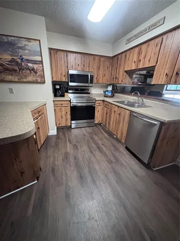 a kitchen with stainless steel appliances a stove top oven a sink and a microwave