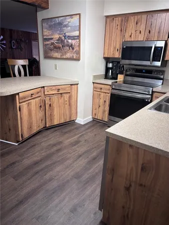 a kitchen with kitchen island granite countertop a sink and a stove
