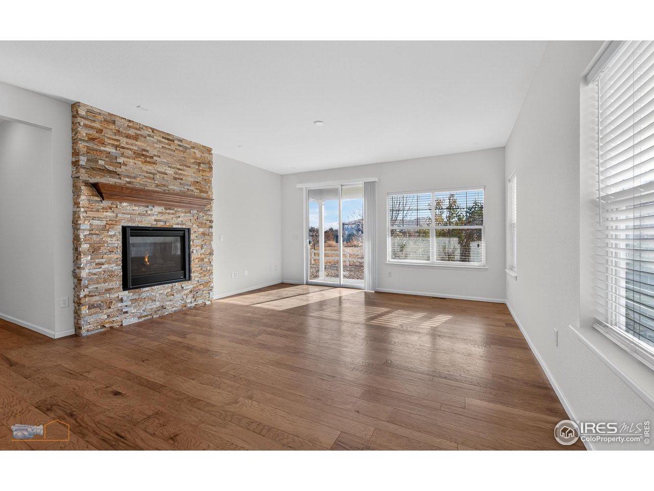 1435 Rustic Drive Longmont, CO 80504 - Photo 14 of 45 a view of an empty room with window and wooden floor