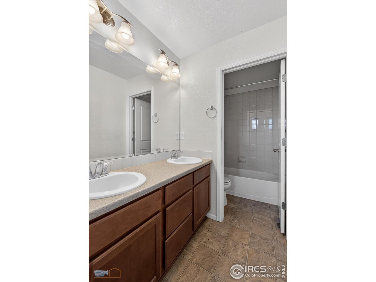 1435 Rustic Drive Longmont, CO 80504 - Photo 31 of 45 a spacious bathroom with a granite countertop sink mirror and a bathtub