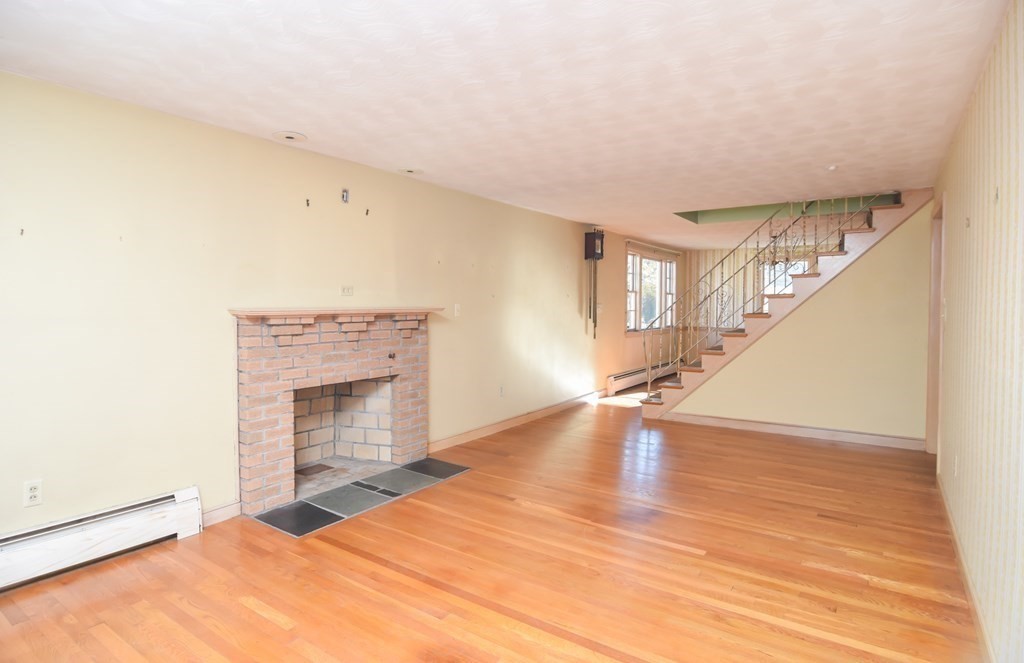 86 Clark Street Dedham, MA 02026 - Photo 9 of 28 a view of empty room with wooden floor and fireplace