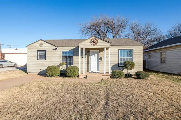 a front view of a house with a yard outdoor seating and garage