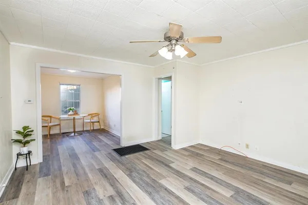 a view of a room with wooden floor and ceiling fan