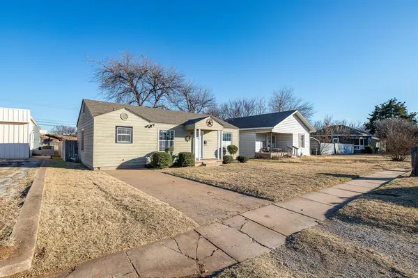 a view of house with yard and car parked
