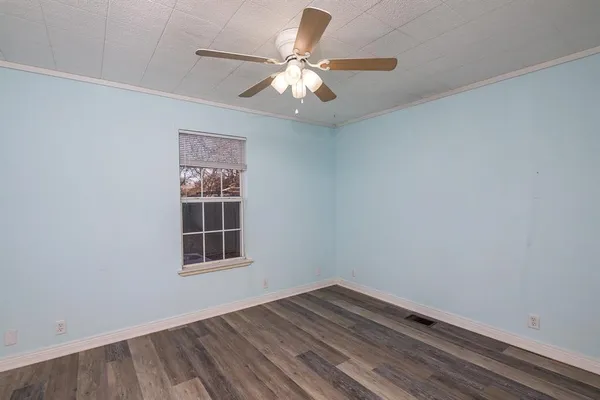 a view of wooden floor and a chandelier fan in a room