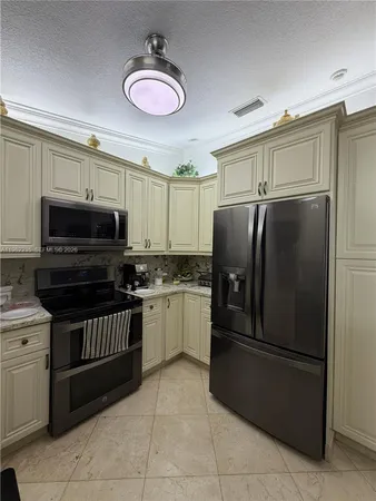 a kitchen with stainless steel appliances granite countertop a refrigerator and a stove top oven