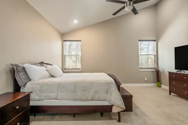 a bedroom with a bed and a flat tv screen on a dresser