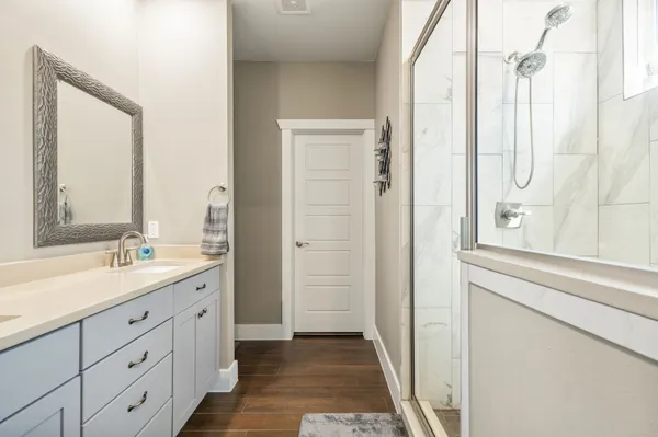 a bathroom with a double vanity sink and mirror with shower