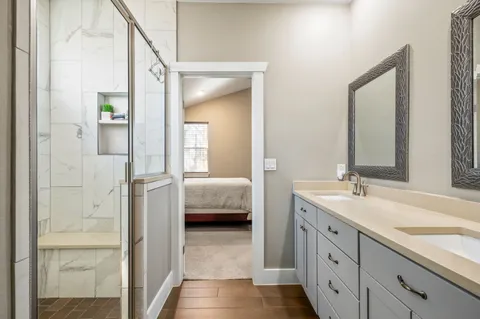 a en suite bathroom with a double vanity sink and a mirror