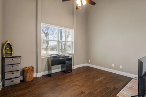 a view of a room with wooden floor and fan