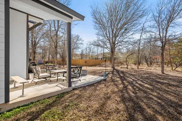 a view of a yard with wooden fence