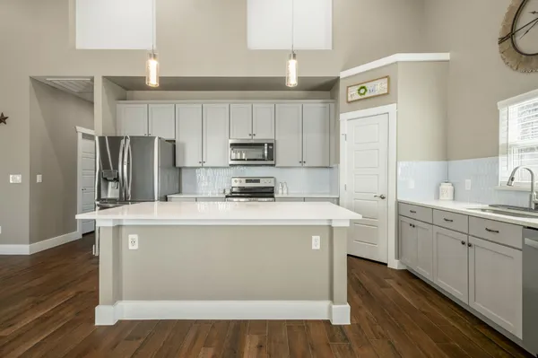 a kitchen with kitchen island white cabinets and stainless steel appliances