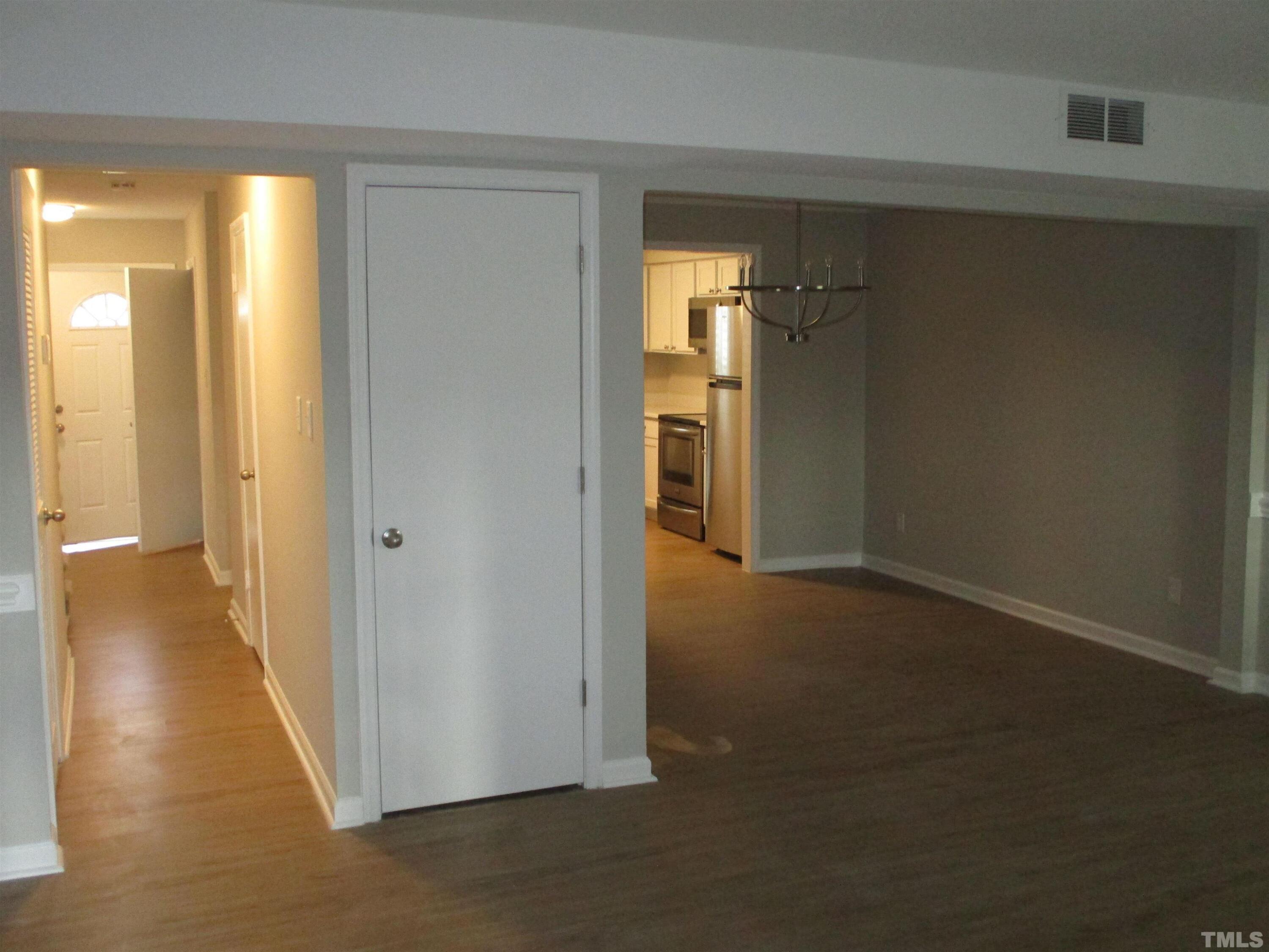 6435 New Market Way Raleigh, NC 27615 - Photo 6 of 17 a view of a hallway with wooden floor and a living room